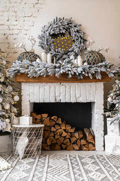 The fireplace is decorated in a New Year's style. Snow-covered trees, Christmas lights and many candles
