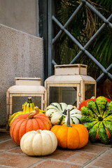 Series of colorful market pumpkins in front of the front door with lanterns