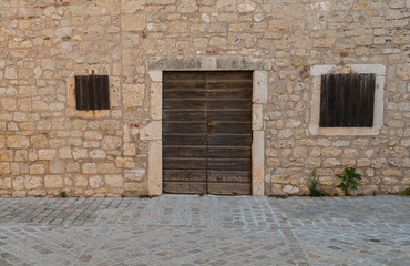 old wooden door in the wall made from limestone