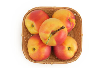 Ripe nectarine fruit in a wicker basket isolated on white background. Top view. Flat lay