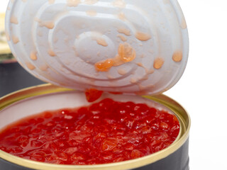 Open tin can with red caviar on a white background. Red caviar close-up.
