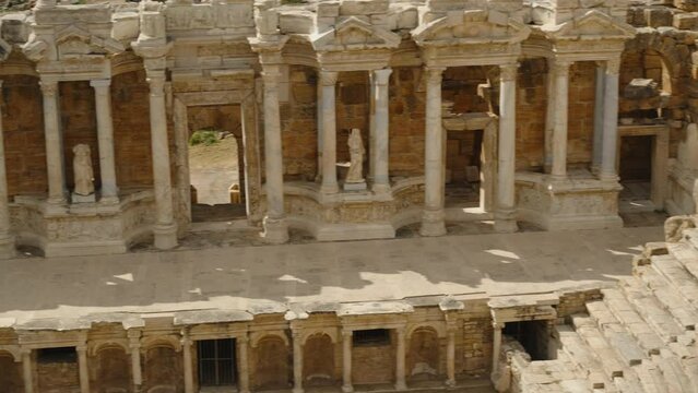 Panorama from the Top of the Ancient Amphitheater, Columns, and Stone Statues Below. approximation