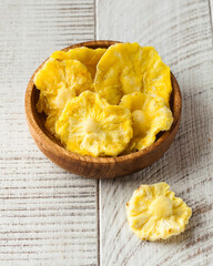 Pieces of candied pineapple on a light wooden background. healthy food, sweets.