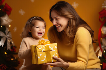 Fototapeta na wymiar Mom and child open a gift for Christmas, yellow background