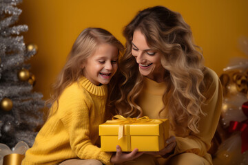 Fototapeta na wymiar Mom and child open a gift for Christmas, yellow background