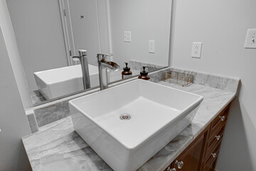Interior of Modern Apartment Bathroom with Luxury Sink and Marble Stone Countertops and Wood Vanity with Mirror