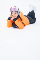 Skier girl posing laying on the snow.