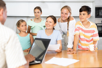 Obraz premium Man is typing on laptop and listening to joyful wife read aloud letter to her family. Positive changes, promotion, successful contract