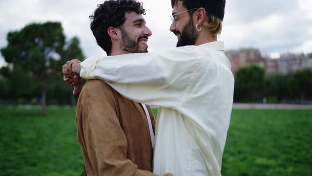 Gay Spanish couple in love in an embrace looking into each other's eyes and kissing. Gay men are happy and in love with each other. Homosexual identity. Lgbt Male in love hug each other and caress