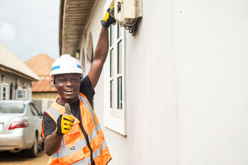 african electrician working on connections at a home