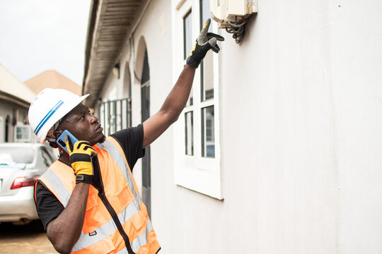 african electrician working making a phone call