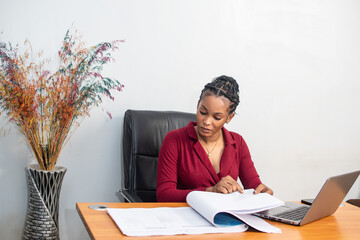 beautiful young african lady busy with work in her office