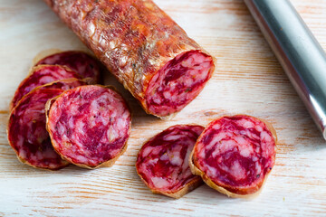 Obraz premium Close-up of spanish salchichon sausage at wooden surface, nobody