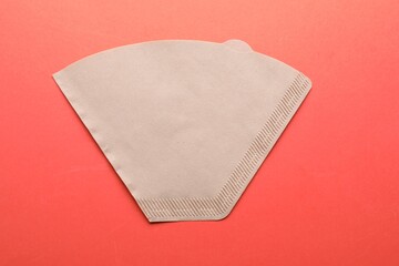 Paper coffee filter on orange background, top view
