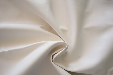Ivory cream on crumpled silk, satin fabric textures detail abstract background.