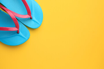 Stylish flip flops on yellow background, flat lay with space for text