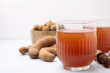 Tamarind juice and fresh fruits on white table, closeup. Space for text