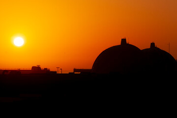 Fototapeta na wymiar Silhouette of San Onofre nuclear power plant main reactors at sunset with sun visible.