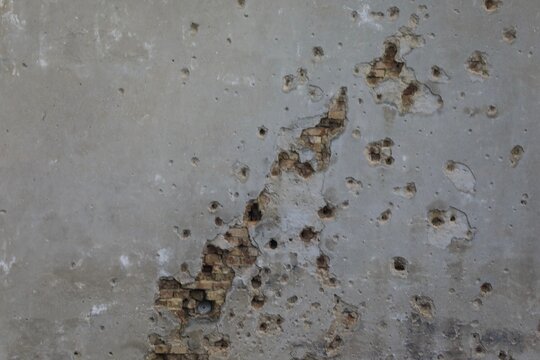 Bullet and mortar holes damage the building facade 