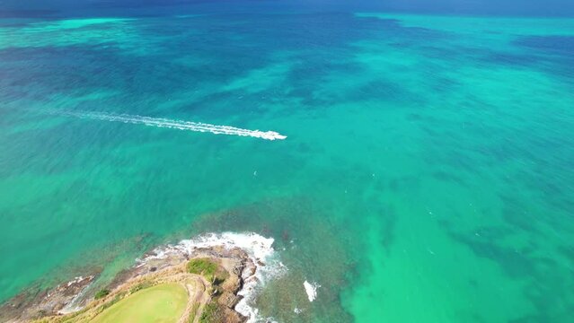 Aerial drone shot of boat passing by st. thomas coki beach sapphire beach turquoise water waves blue sky white clouds east end red hook
