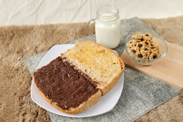 Bread with chocolate spread filling, milk and snack for breakfast