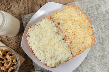 Bread with cheese, sweetened condensed milk, and butter. With white milk and snack on a table for breakfast
