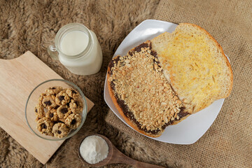 Bread with peanut, chocolate and butter spread on a table for breakfast