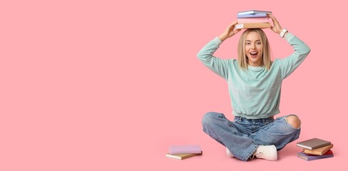 Obraz na płótnie Canvas Young happy woman with many books sitting against pink background with space for text