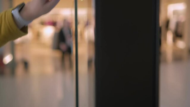 Girl using a touch terminal in a shopping mall. The concept of people and technologies. Online Router