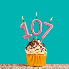 Birthday card with number 107 candle on aquamarine background