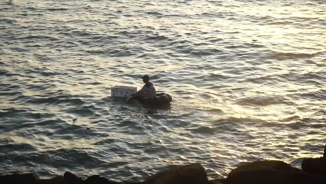 A fisherman is fishing using a traditional boat.