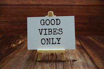 Good Vibes Only text on paper card on wooden background