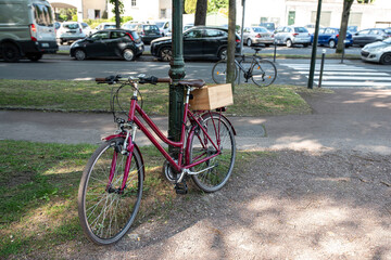 A bicycle parked in the city with a box on its rack