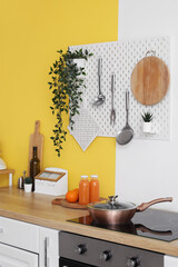 Interior of stylish kitchen with pegboard, wooden counters and electric stove