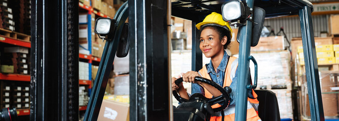 Portrait of a female worker with a forklift in the warehouse., Industrial and industrial concept. © NewSaetiew