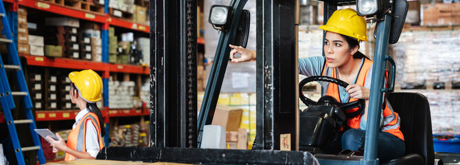 Portrait of a woman working with a forklift in a warehouse.