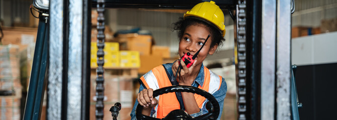 Portrait of a female worker with a forklift in the warehouse., Industrial and industrial concept. © NewSaetiew
