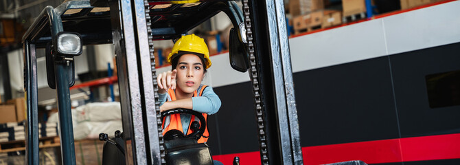 Portrait of a woman working with a forklift in a warehouse. - obrazy, fototapety, plakaty