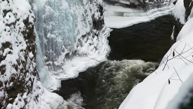 Mountain river running through ice covered gorge, Ausable Chasm in Adirondacks