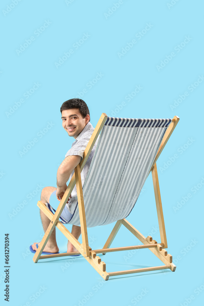 Sticker young man relaxing in deck chair on blue background