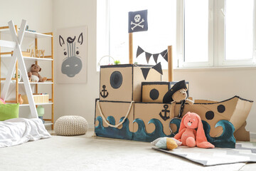 Pirate cardboard ship with toys in children's bedroom