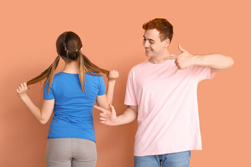 Young couple in t-shirts on beige background