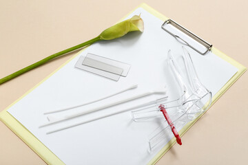 Gynecological speculum with pap smear test tools and clipboard on light background