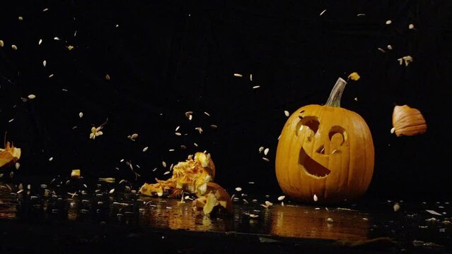 Pumpkin shattering near jack-o-lantern in slow motion - halloween