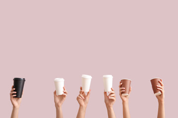 Female hands with different takeaway paper cups on purple background