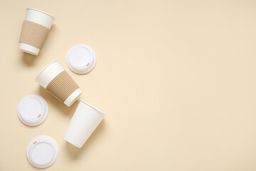 Takeaway paper cups with lids on beige background