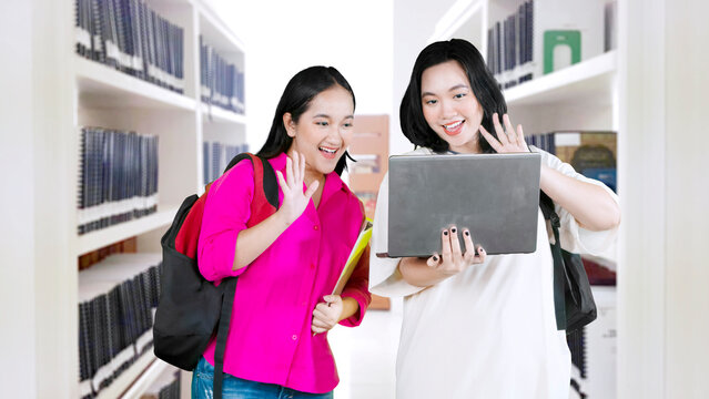 Asian young women using laptop pc computer waving hand doing video conference
