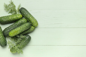 Heap of fresh cucumbers with dill on green wooden background