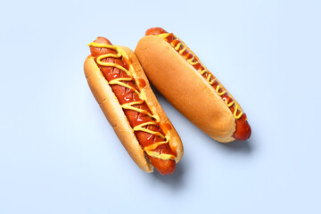 Tasty hot dogs with mustard and ketchup on blue background
