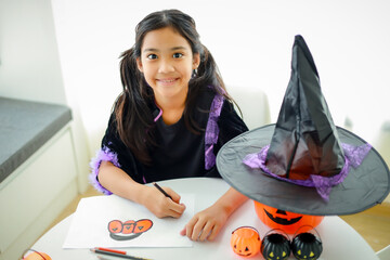 Halloween, holiday and childhood concept. Little kids southeast asian on halloween dressed in a witch costume.